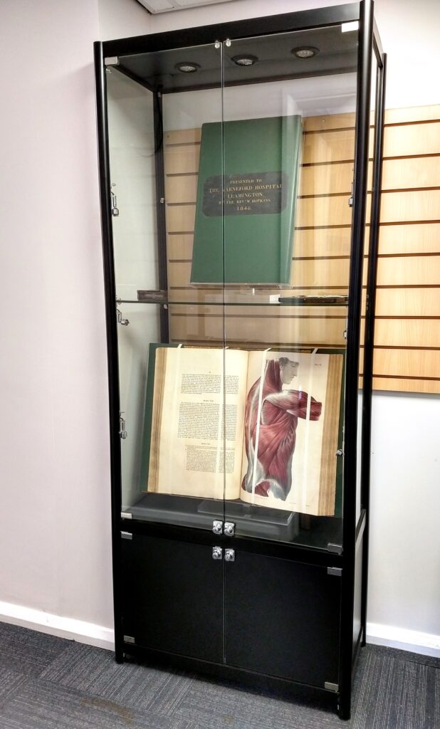 Display cabinet containing historic anatomy textbooks and artefacts